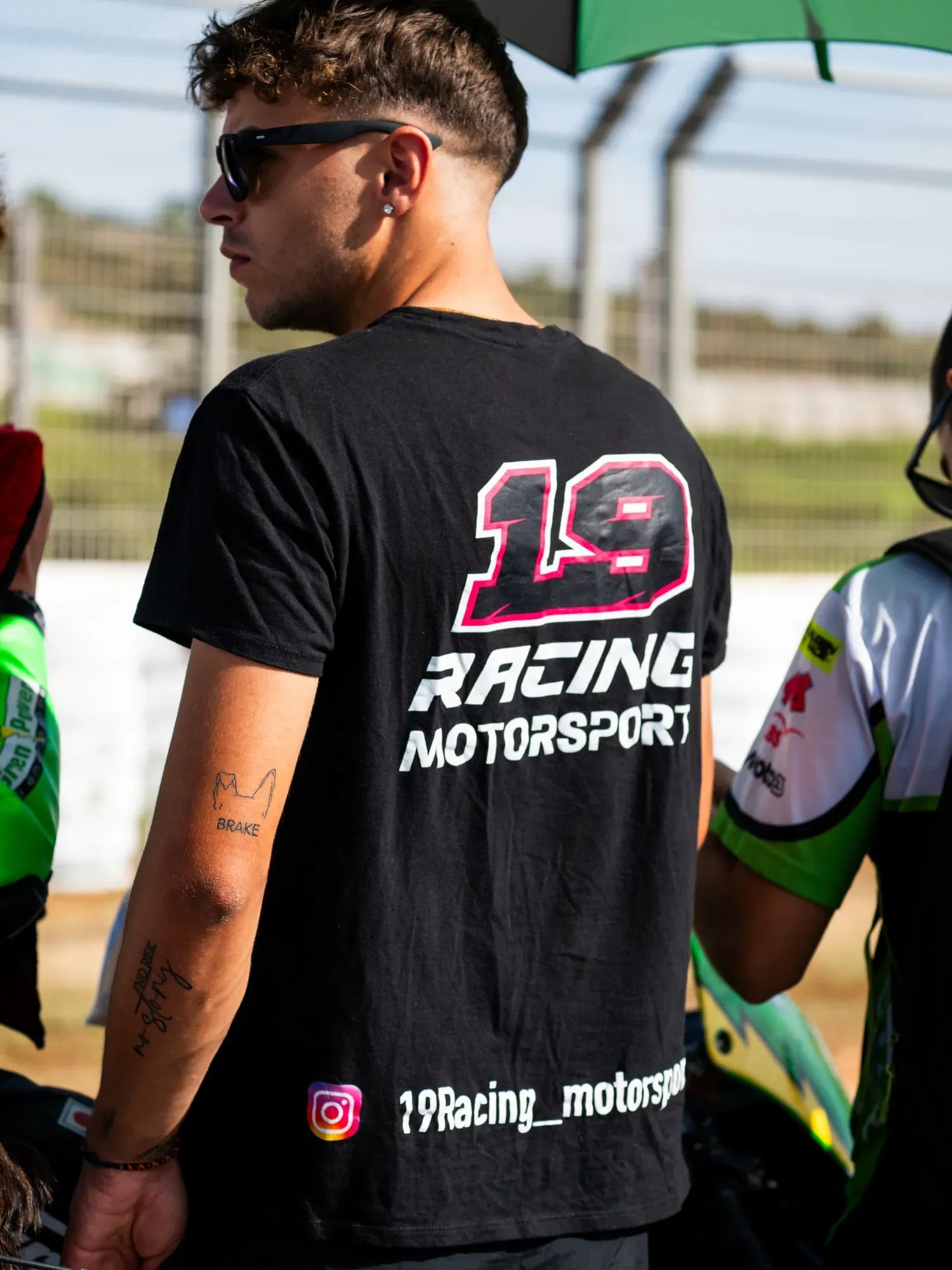 Miembro del equipo con la camiseta de 19 Racing Motorsport en el paddock de un circuito