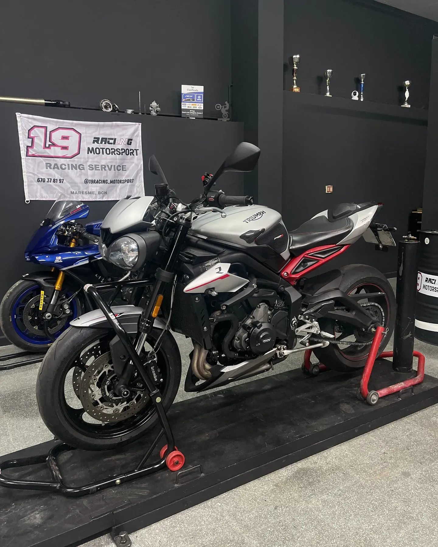 Triumph Street Triple sobre caballetes en el taller, bajo la bandera de 19 Racing Motorsport